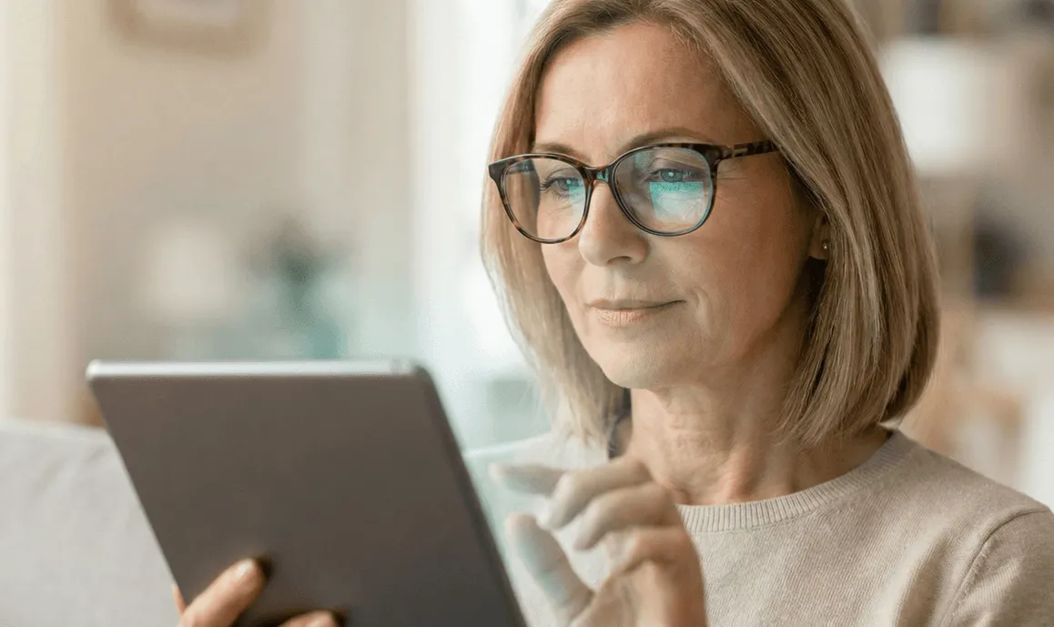 Een vrouw met een bril doet een geheugentest op een tablet.